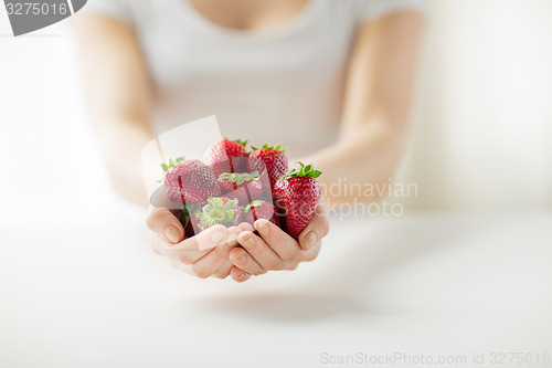 Image of close up of woman hands holding strawberries