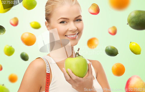 Image of happy sporty woman with apple and measuring tape