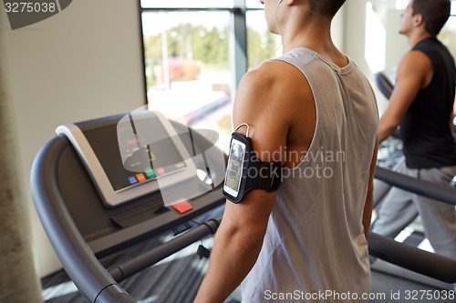 Image of smiling men exercising on treadmill in gym