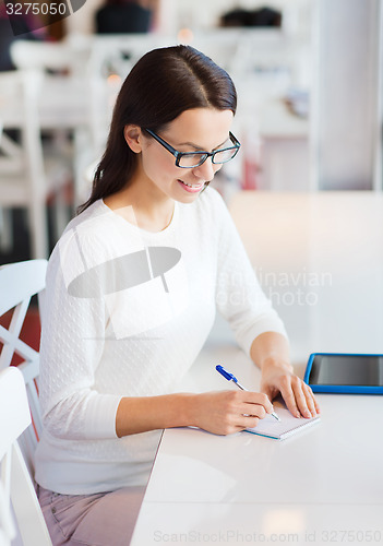 Image of smiling woman with tablet pc at cafe