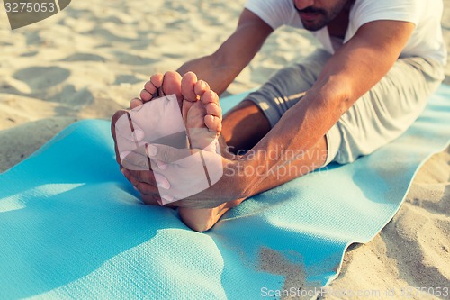 Image of close up of man making yoga exercises outdoors