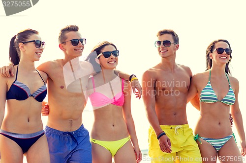 Image of smiling friends in sunglasses on summer beach