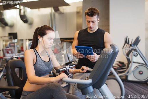 Image of woman with trainer on exercise bike in gym