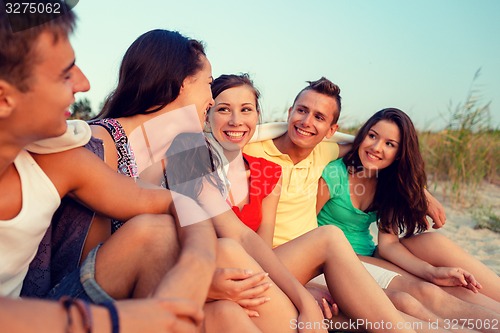 Image of smiling friends in sunglasses on summer beach