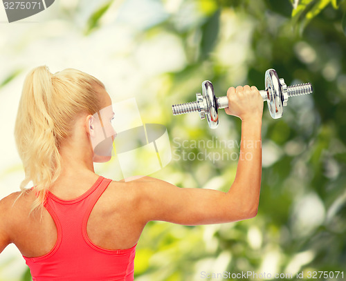 Image of sporty woman with heavy steel dumbbell from back