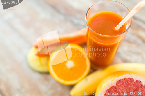 Image of close up of fresh juice glass and fruits on table