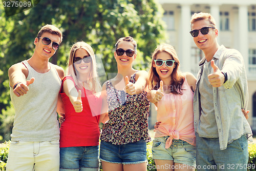 Image of group of smiling friends showing thumbs up