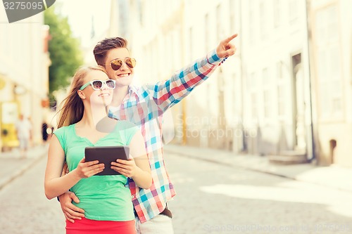 Image of smiling couple with tablet pc in city