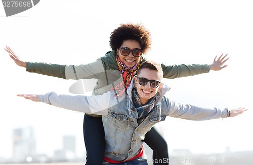 Image of happy teenage couple in shades having fun outdoors