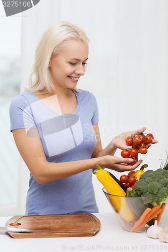 Image of smiling young woman cooking vegetables at home