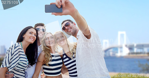 Image of friends taking selfie with smartphone