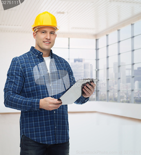 Image of smiling male builder in helmet with clipboard