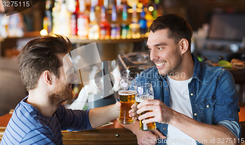 Image of happy male friends drinking beer at bar or pub