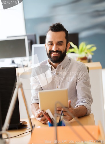 Image of happy creative male office worker with tablet pc