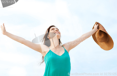 Image of girl with hands up on the beach