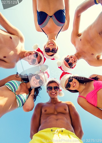 Image of smiling friends in circle on summer beach