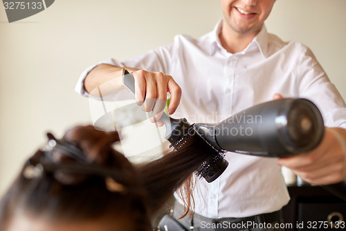 Image of  close up of stylist making hairdo at salon