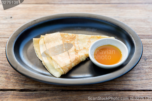 Image of close up of pancakes and honey or jam on plate