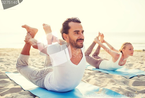 Image of couple making yoga exercises outdoors