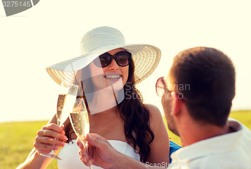 Image of smiling couple drinking champagne on picnic