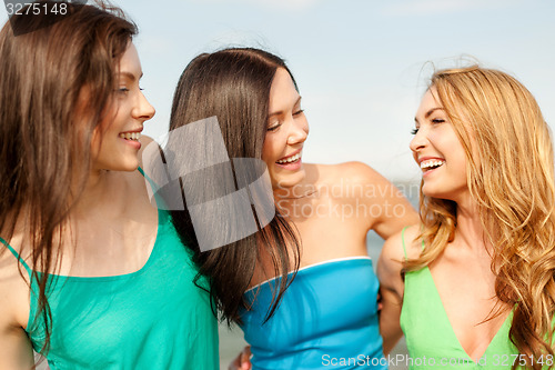 Image of smiling girls walking on the beach