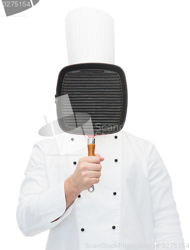 Image of male chef cook covering face with grill pan