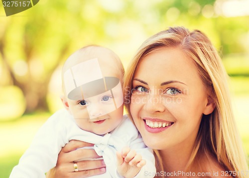 Image of close up of happy mother with little baby in park