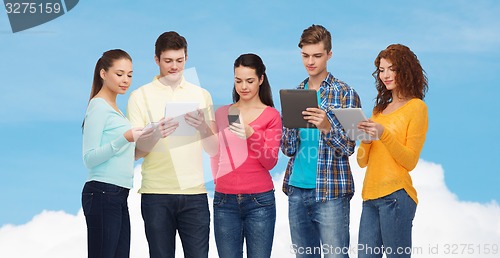 Image of group of teenagers with smartphones and tablet pc