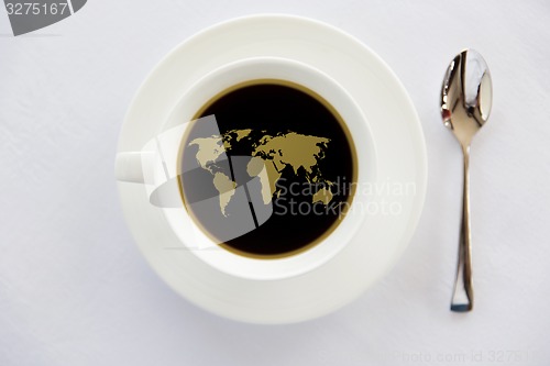 Image of world map in cup of black coffee with spoon