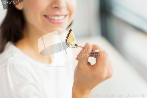 Image of close up of woman eating cake at cafe or home