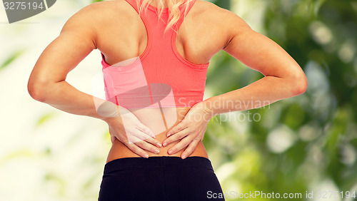 Image of close up of sporty woman touching her back