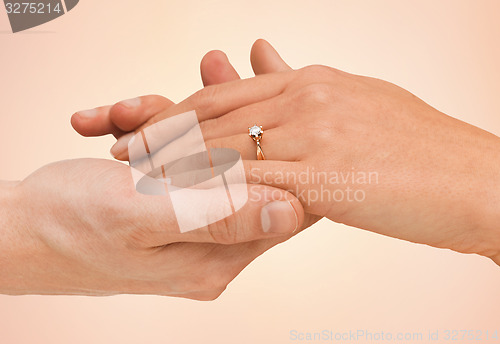 Image of close up of man and woman hands with wedding ring