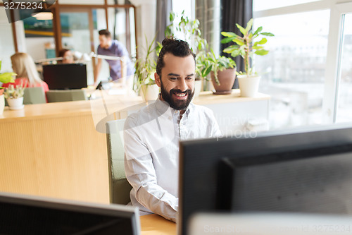 Image of happy creative male office worker with computer