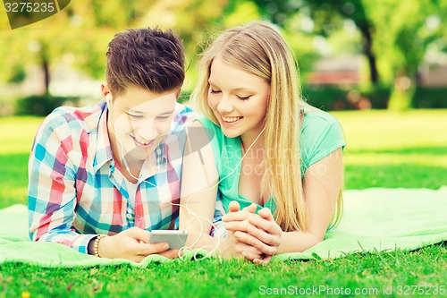 Image of smiling couple with smartphone and earphones