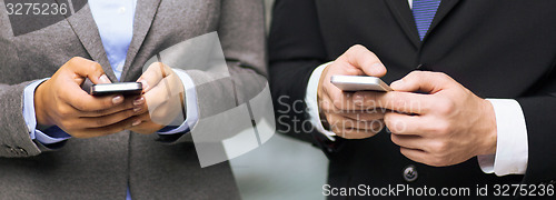 Image of businessman and businesswoman with smartphones