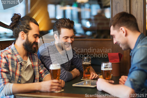 Image of male friends with tablet pc drinking beer at bar