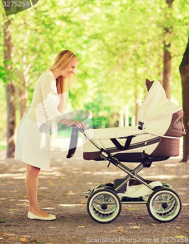 Image of happy mother with stroller in park