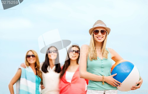 Image of girl with ball and friends on the beach