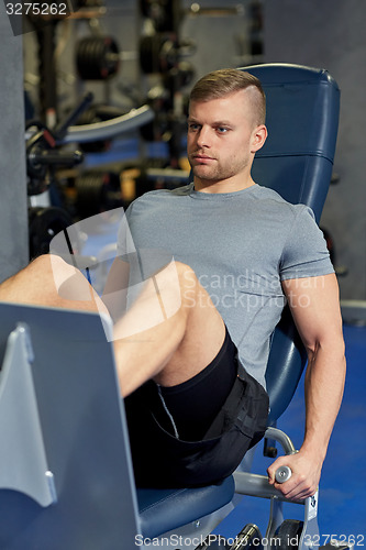 Image of man flexing leg muscles on gym machine