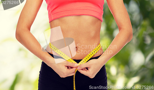 Image of close up of female hands measuring waist