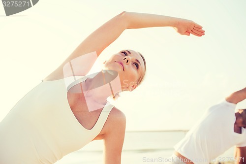 Image of close up of couple making yoga exercises outdoors