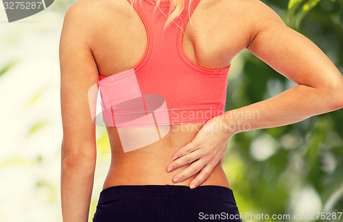 Image of close up of sporty woman touching her back