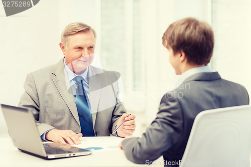 Image of older man and young man having meeting in office