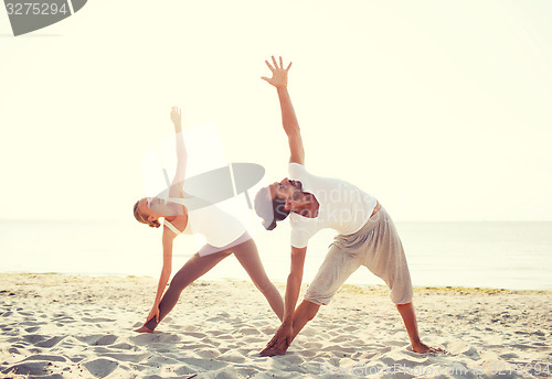 Image of couple making yoga exercises outdoors