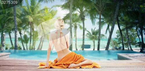 Image of woman with orange towel over tropical beach