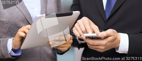 Image of two businesspeople with smartphone and tablet pc