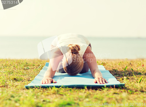 Image of close up of woman making yoga exercises outdoors