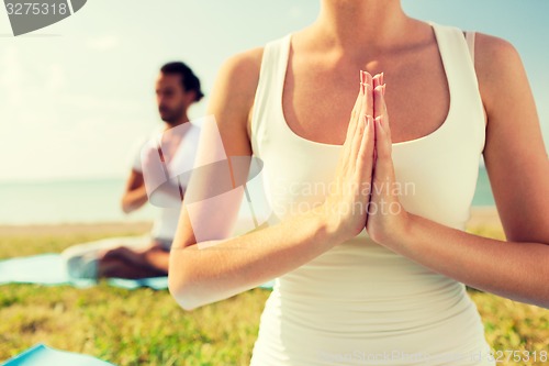 Image of close up of couple making yoga exercises outdoors