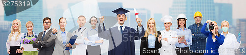 Image of happy bachelor with diploma over professionals