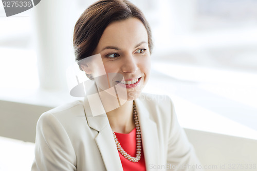 Image of happy elegant young woman in jacket at office